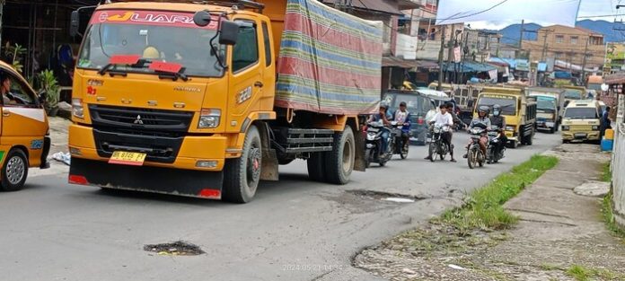 Arus lalu lintas semakin macet karena jalan berlubang di Jalan Pakpak - Sitelunempu dilewati truk over tonase (f:manru/mistar)