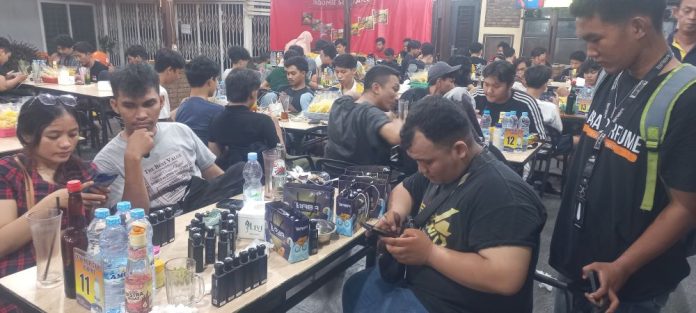 Dayat dan Ali sedang menawarkan dan menjelaskan tentang produk dan bisnis yang mereka jalankan, pada pengunjung di salah satu warkop di Kota Medan