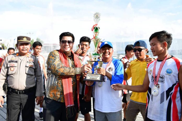 Bupati Samosir Vandiko Gultom menyerahkan piala kepada tim Siogung-ogung.(f:ist/Mistar)