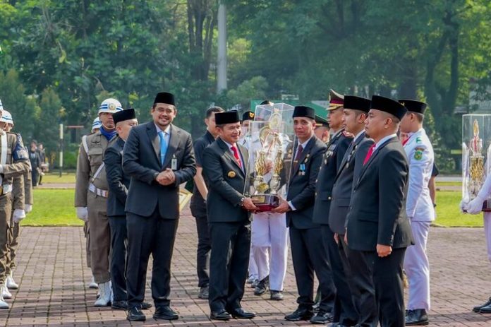 Pj Sumut, Hasanuddin didampingi Wali Kota Medan, Bobby Nasution saat menyerahkan piala kepada Camat Medan Johor (f:ist/mistar)