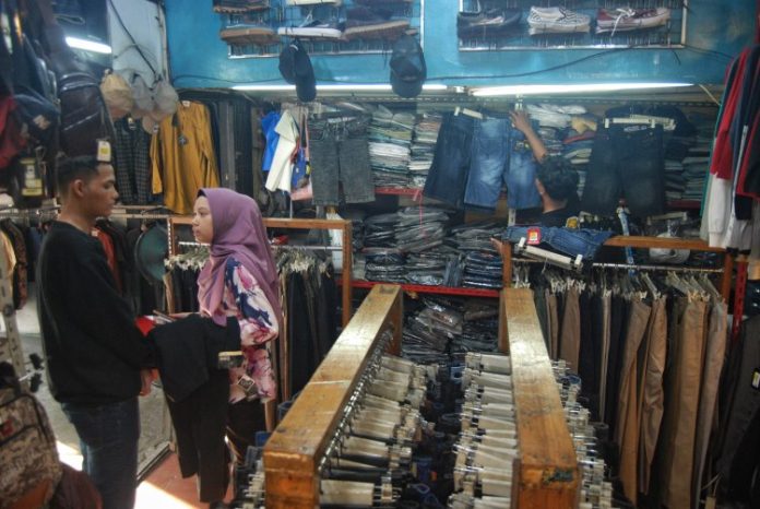 Pekerja melayani calon pembeli di salah satu toko pakaian di Medan, Sumatera Utara