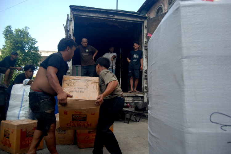 Sejumlah pekerja informal di Medan mengangkat barang