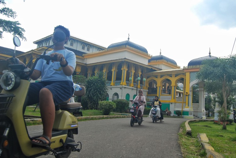 Sejumlah wisatawan mengendarai kereta listrik berkeliling halaman Istana Maimun Medan