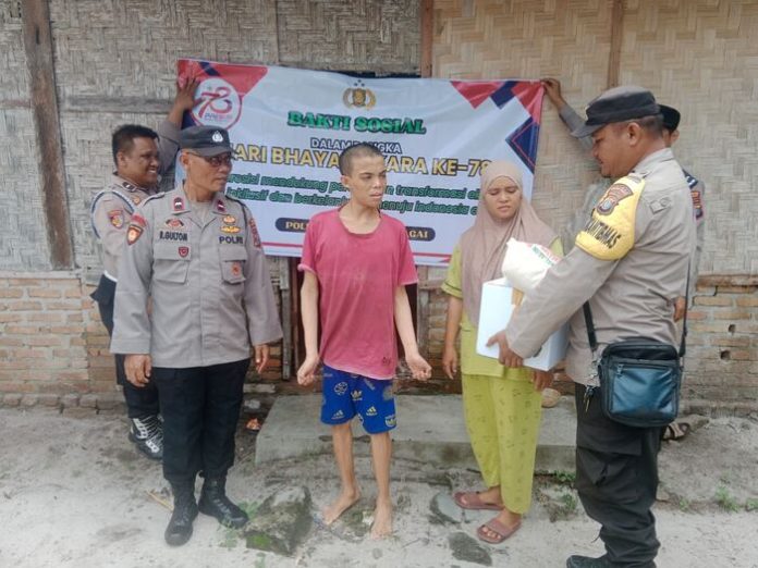 Personel Polsek Tanjung Beringin saat memberikan bansos ke warga (f:ist/mistar)