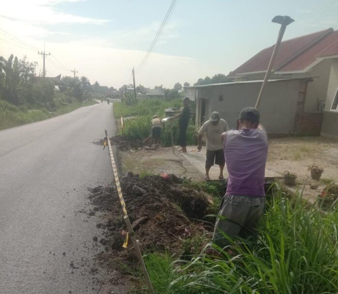 Petugas Perumda Tirtauli tengah memperbaiki pipa pecah di Jalan Saribu Dolok (f:gideon/mistar)