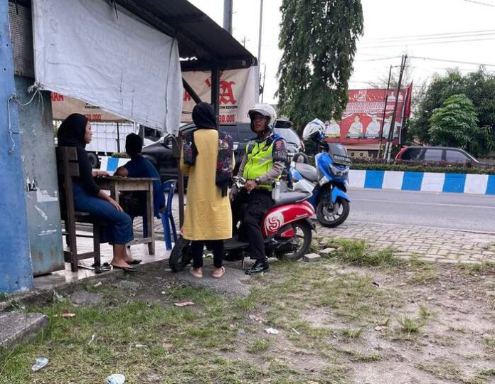 Oknum Polantas yang mematok bayaran kepada pengendara sepeda motor yang tidak memakai helm.(f: sembiring/mistar)