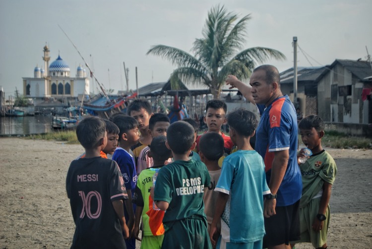 Ilham (42) warga belawan yang mendedikasikan dirinya sebagai pelatih sepak bola anak-anak sejak setahun terakhir tanpa di bayar