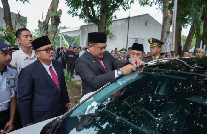 Wali Kota Medan, Bobby Nasution saat memasangkan stiker parkir berlangganan (f:ist/mistar)
