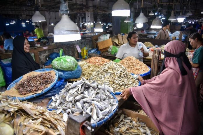 Pedagang ikan asin melayani calon pembeli saat berbelanja di Pusat Pasar, Kota Medan
