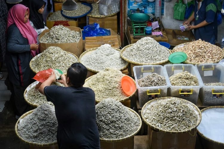 Pedagang membungkus ikan asin untuk pembeli di Pusat Pasar, Kota Medan