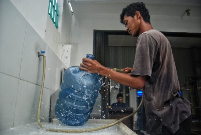 Pekerja membersihkan galon di salah satu Depot Air Minum Dalam Kemasan (AMDK) di Kota Medan