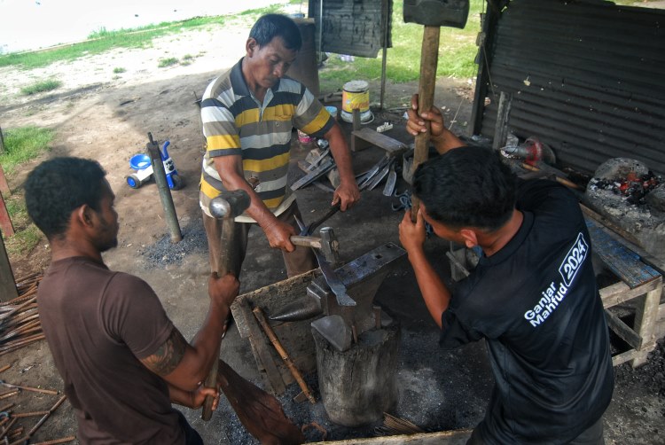 Perajin menempa besi untuk membuat parang (golok) di Desa Bandar Khalipa, Percut Sei Tuan, Deli Serdang