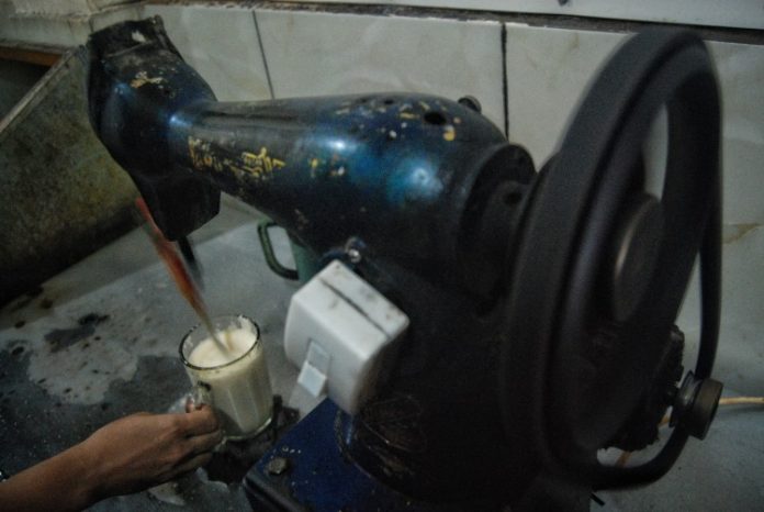 Proses pembuatan minuman teh susu telur yang unik menggunakan mesin jahit modifikasi di Medan