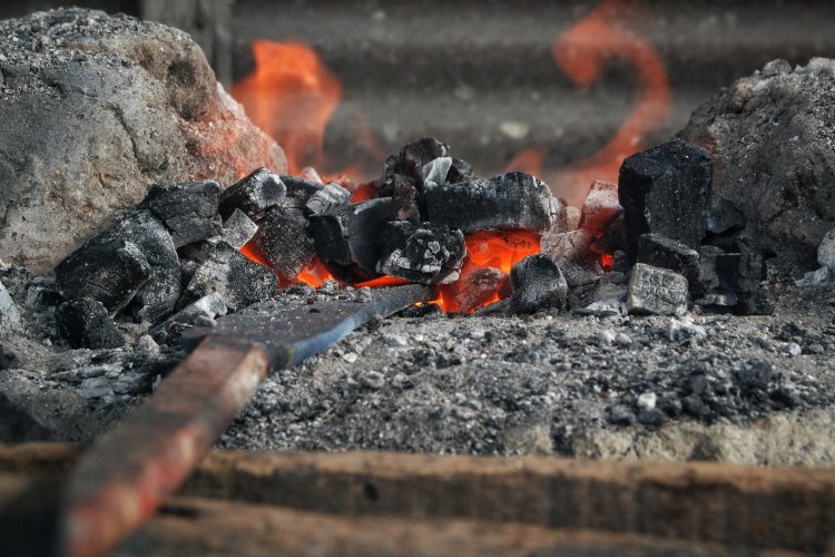 Sebilah golok sedang dipanaskan di bengkel pandai besi di Deli Serdang