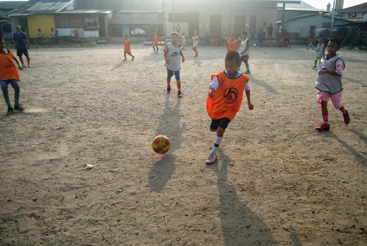 Sejumlah anak bermain sepak bola di Lahan Gedung Serbaguna Gudang Arang, Medan Belawan