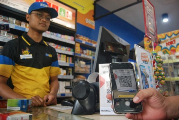 Konsumen memindai kode batang pembayaran digital Quick Response Indonesia Standard (QRIS) di Store Yes 248, Medan, Sumatera Utara