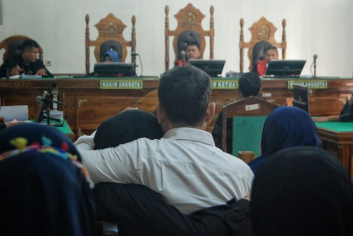 Mantan Kadinkes Sumut Alwi Mujahit Hasibuan memeluk anaknya usai mendengarkan tuntutan dari jaksa penuntut umum di Pengadilan Negeri Medan
