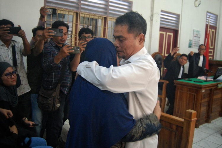 Mantan Kadinkes Sumut Alwi Mujahit Hasibuan memeluk istrinya usai mendengarkan tuntutan dari jaksa penuntut umum di Pengadilan Negeri Medan