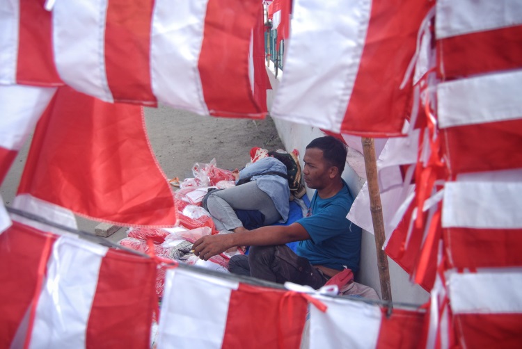 Pedagang musiman pernak-pernik HUT Ke-79 RI beristirahat di kawasan Taman Makam Pahlawan, Medan, Sumatera Utara
