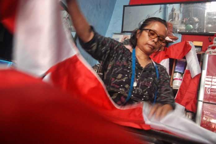 Penjahit bendera Merah Putih di Medan, Sumatera Utara sedang melipat hasil jahitannya