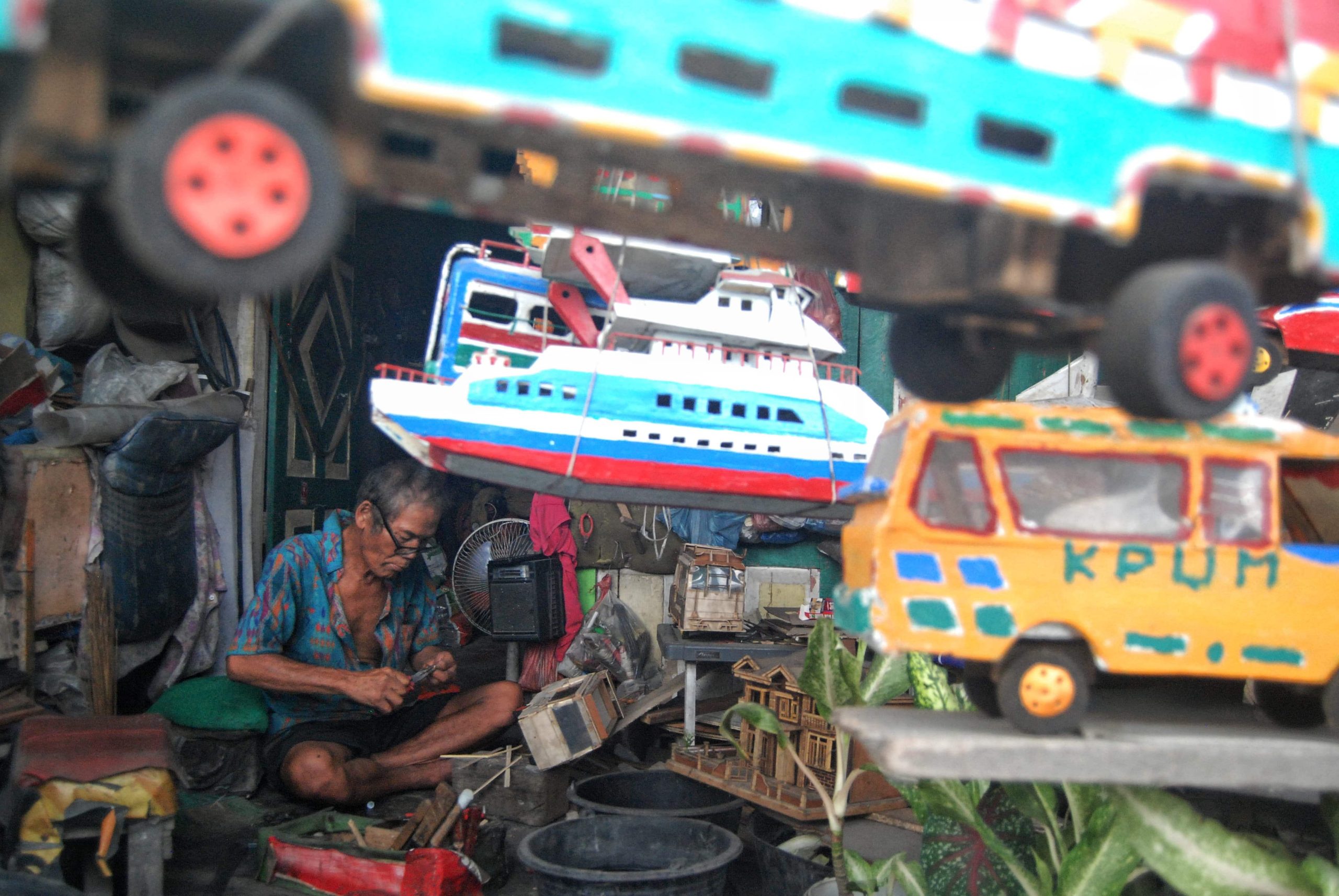 Seorang perajin Simon Simarmata (60) menyelesaikan pembuatan kerajinan miniatur mobil-mobilan berbahan baku kayu dari barang rongsokan di bengkel kerja Pardosi, Jalan Mandala, Medan, Sumatera Utara