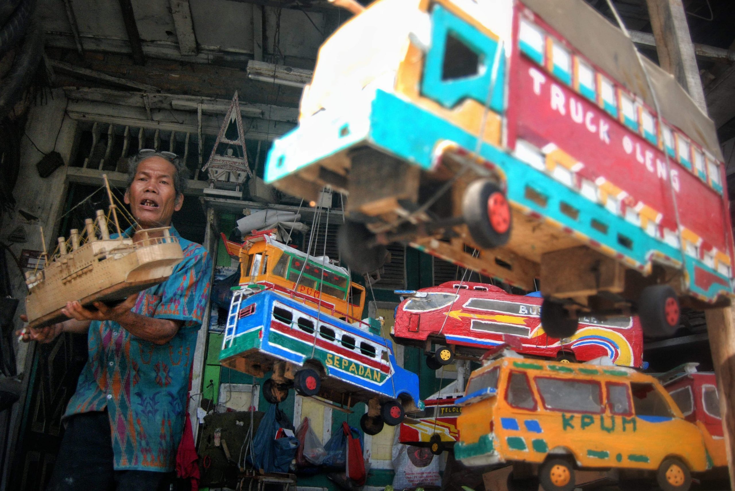 Seorang perajin miniatur mobil-mobilan berbahan baku kayu dari barang rongsokan menunjukkan hasil karyanya di bengkel kerja Pardosi, Jalan Mandala, Medan, Sumatera Utara