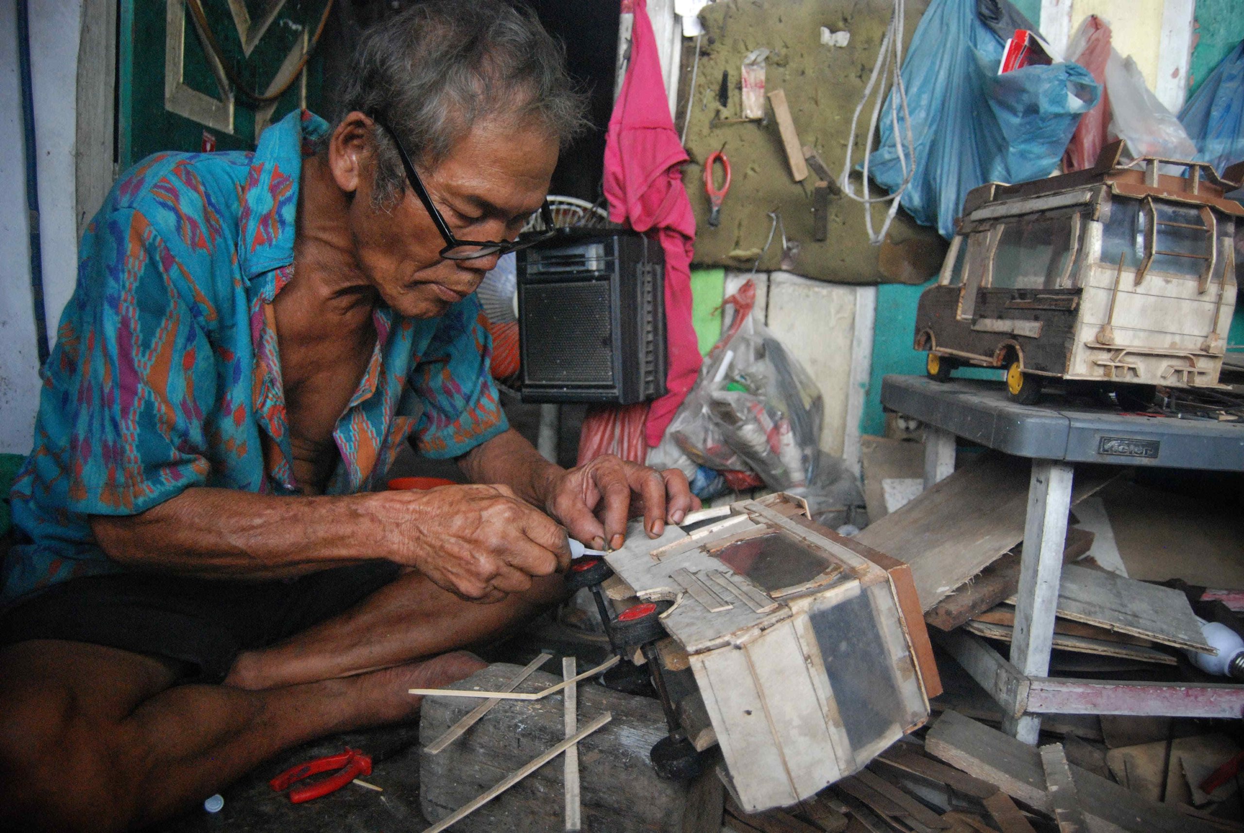 Simon Simarmata dengan serius menyelesaikan pembuatan kerajinan miniatur mobil-mobilan berbahan baku kayu dari barang rongsokan menunjukkan hasil karyanya di bengkel kerja Pardosi, Jalan Mandala, Medan, Sumatera Utara