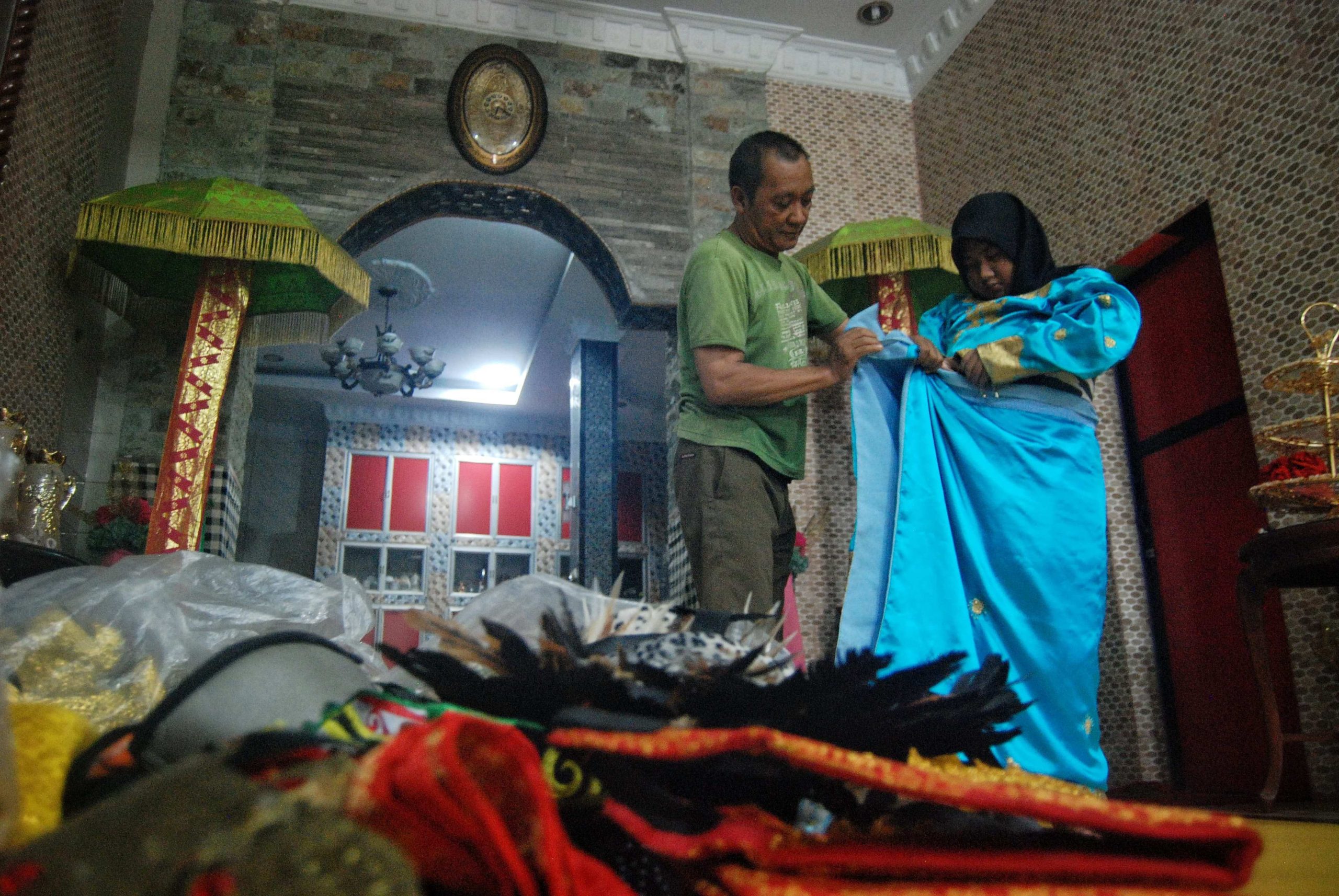 Warga mencoba baju adat di Astakona Production, Jalan Selamat, Medan, Sumatera Utara