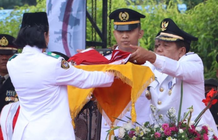 Bupati Simalungun Radiapoh Hasiholan Sinaga menyerahkan bendera merah putih kepada pembawa baki dalam perayaan Kemerdekaan Republik Indonesia. (f:ist/mistar)