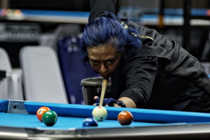 Atlet biliard Daerah Istimewa Yogyakarta Lafitri memukul bola pada pertandingan penyisihan Nine Ball Single Putri PON XXI Aceh-Sumut di Pardede Hall, Medan