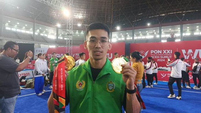 Atlet Wushu Taolu Sumatera Utara(Sumut), Harris Horatius berpose dengan medali emas PON XXI 2024.