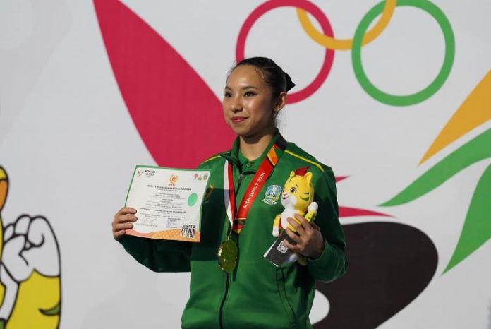 Atlet Wushu Jatim, Jennifer Tjahyadi berpose dengan medali emasnya.