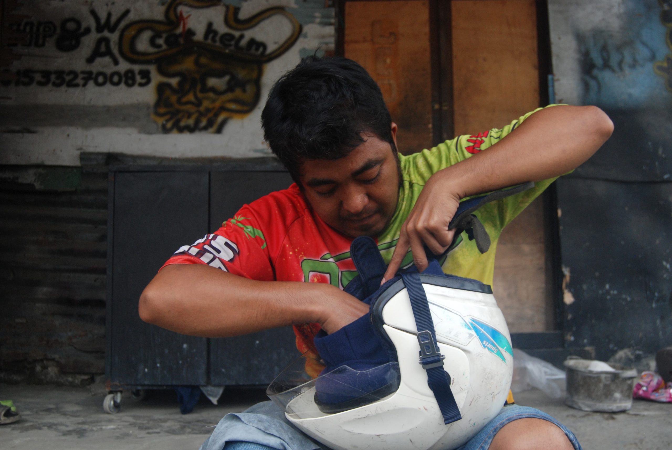 Leo menyusun kembali busa dan kain helm setelah di cuci di kios dan revarasi helm miliknya di Jalan Gedung Arca, Medan