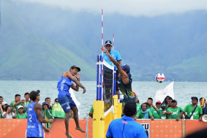 Pebola Voli Pantai Putra Jawa Timur Bintang gagal memblok bola usai menerima smash keras dari pebola voli Nusa Tenggara Barat Ade dalam ajang PON XXI Aceh-Sumut di Pantai Indah Situngkir, Samosir