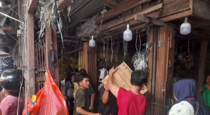 Pedagang di pasar Horas menyelamatkan barang dagangannya