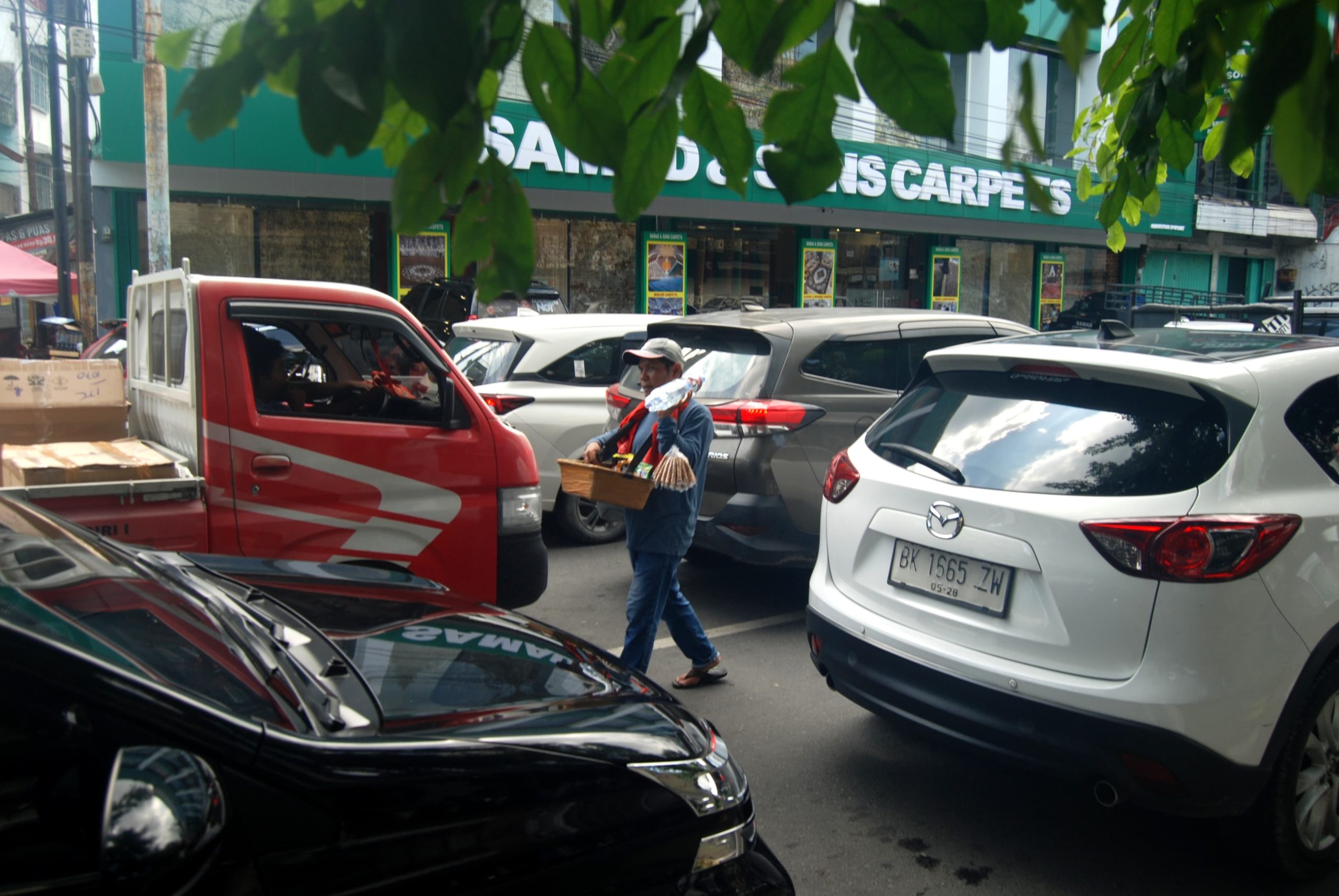 Pedagang rokok asongan Doli menjajakan rokok di persimpangan lampu merah Jalan Brigjen Katamso, Medan