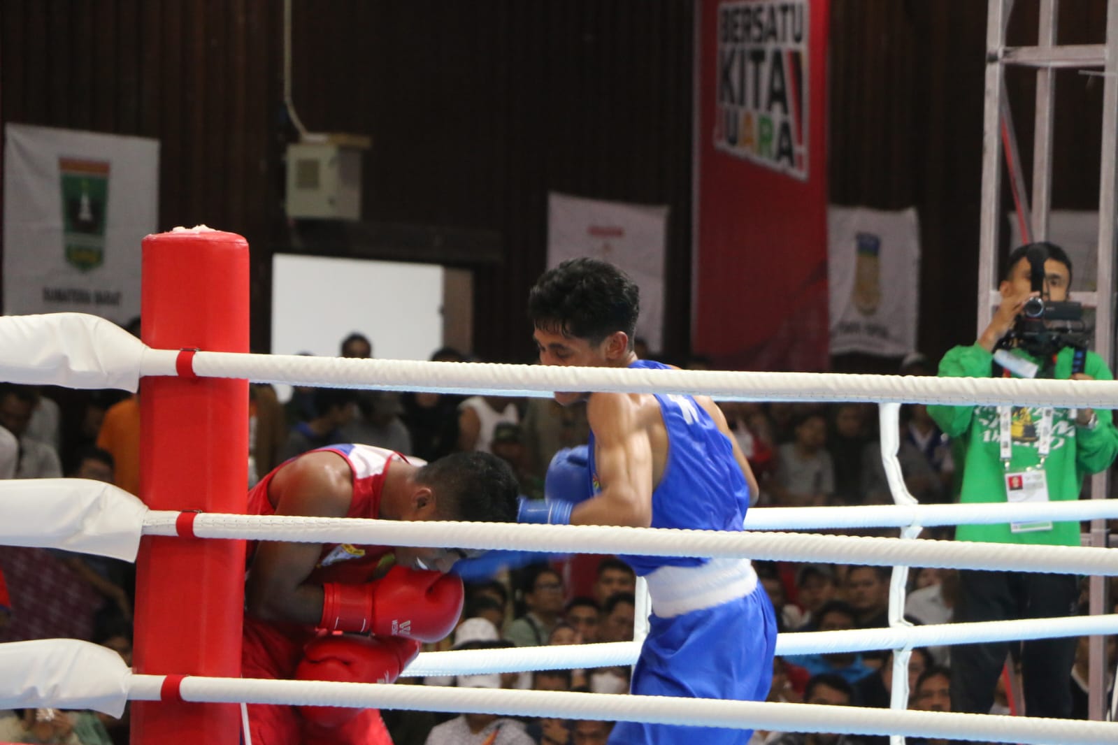 Petinju putra dari NTT, Dio Koebanu (biru) menyudutkan Fernando Ayer asal Papua Barat (merah) pada Babak Penyisihan PON XXI