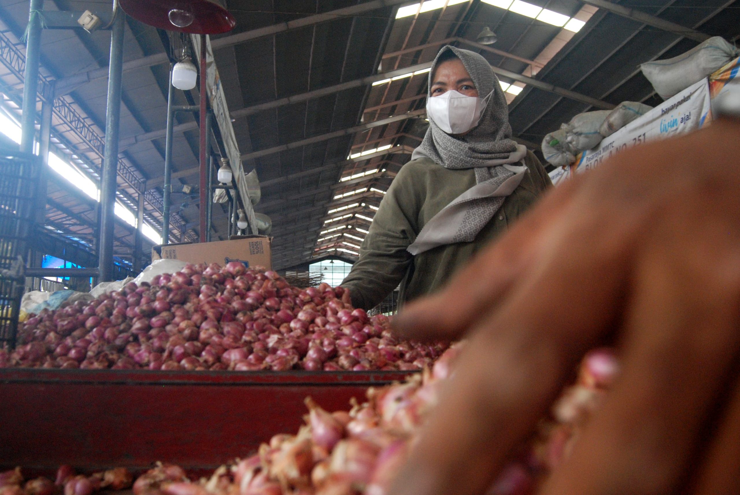 Seorang warga memilih bawang merah di Pasar Aksara, Medan