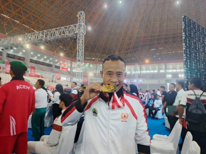 Atlet Wushu asal Jawa Tengah, Yusuf Widiyanto berpose dengan medali emasnya.