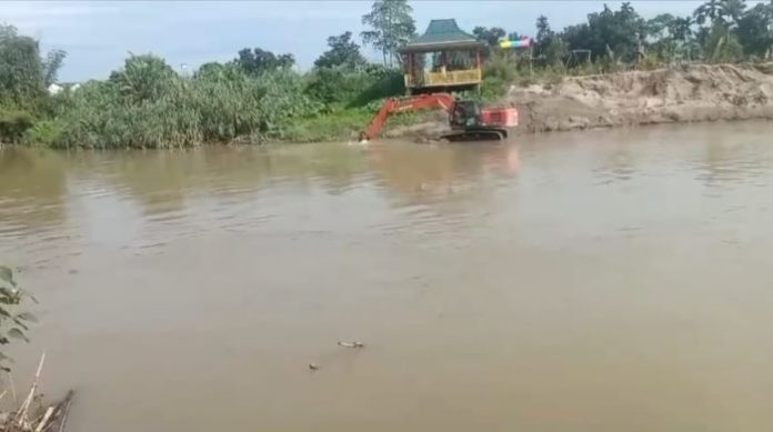 Excavator yang diduga dikelolah oleh AS saat beraktivitas mengeruk dasar sungai padang.