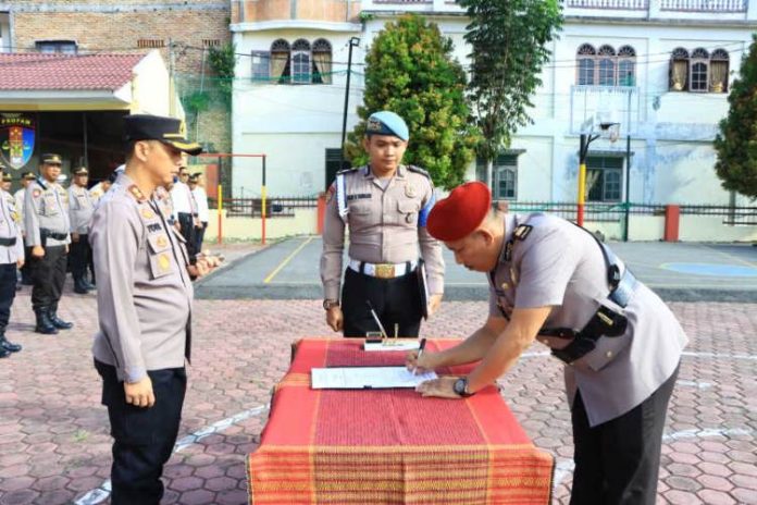 Kapolres Samosir AKBP Yogie Hardiman bersama Iptu Edward Sidauruk menandatangani surat naskah serah terima jabatan Kasat Reskrim Polres Samosir.