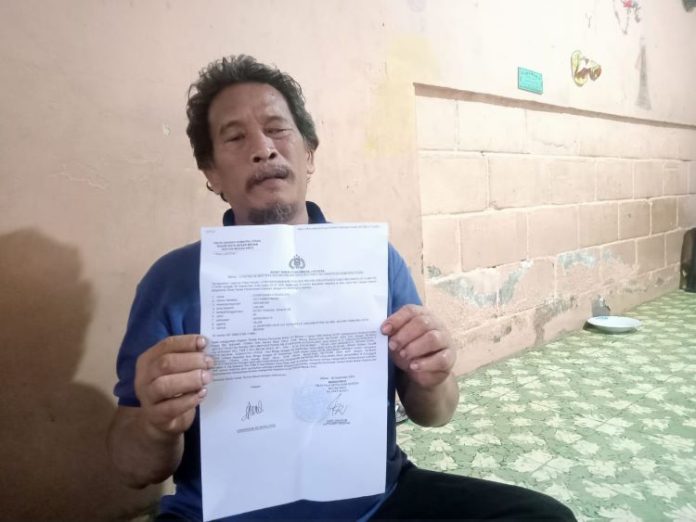 Syabridan Hutagalung (50) memperlihatkan surat laporan kehilangan sepeda motor yang dibawa kabur pencuri yang modus menolong ia dan istrinya saat terjatuh ke parit.