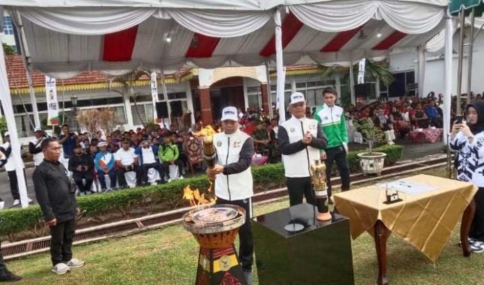 Pj Wali Kota Tebing Tinggi Dr Moettaqien Hasrimi secara simbolis menyalakan api ke tunggu dengan menggunakan Obor PON di Halaman Pj Wali Kota Tebing Tinggi Dr Moettaqien Hasrimi.