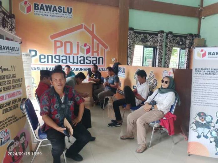 Ketua DPC PDI Perjuangan Labura Sunaryo (baju merah) dan beberapa anggotanya menunggu sidang mediasi bapaslon Ahmad Rizal-Darno yang sedang digelar di kantor Bawaslu Labura di Aekkanopan, Minggu (15/9/24).