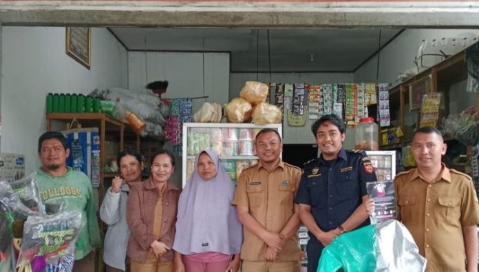 Kepala Dinas Perindagkop UMKM Dairi, Iwan Taruna Berutu bersama personel Bea Cukai Siantar saat melakukan tindakan sosialisasi di sejumlah warung penjual rokok. Sidikalang, Selasa (24/9/24).