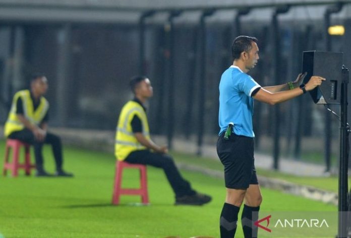 Wasit Yudi Nurcahya memeriksa kejadian melalui monitor Wasit Berbantuan Video (VAR) saat pertandingan leg pertama perebutan tempat ketiga Championship Series Liga 1 2023/2024 antara Bali United melawan Borneo FC Samarinda di Stadion Kapten I Wayan Dipta Gianyar, Bali, Sabtu (25/5/24).