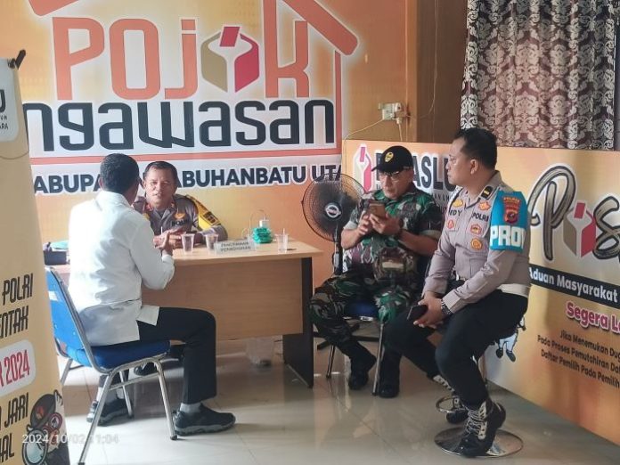 Darno terlihat berbincang bersama Wakapolsek Iptu Sirait dan Kanit Provost Ipda Dedei, serta Serma Simanjuntak di kantor Bawaslu Labura sebelum musyawarah mediasi tertutup