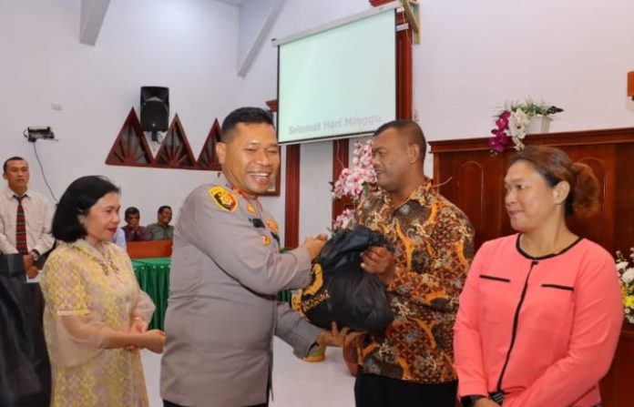 Kapolres Tebing Tinggi AKBP Drs. Simon Paulus Sinulingga, S.H. saat menyerahkan bantuan sembako kepada Jamaat Gereja.(f:Ist/mistar)