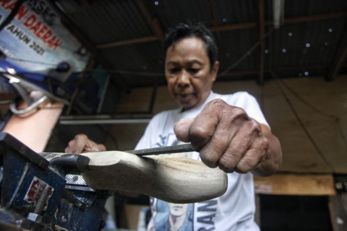 Perajin menyelesaikan pembuatan cetakan sepatu berbahan kayu di Medan Denai, Medan, Sumatera Utara