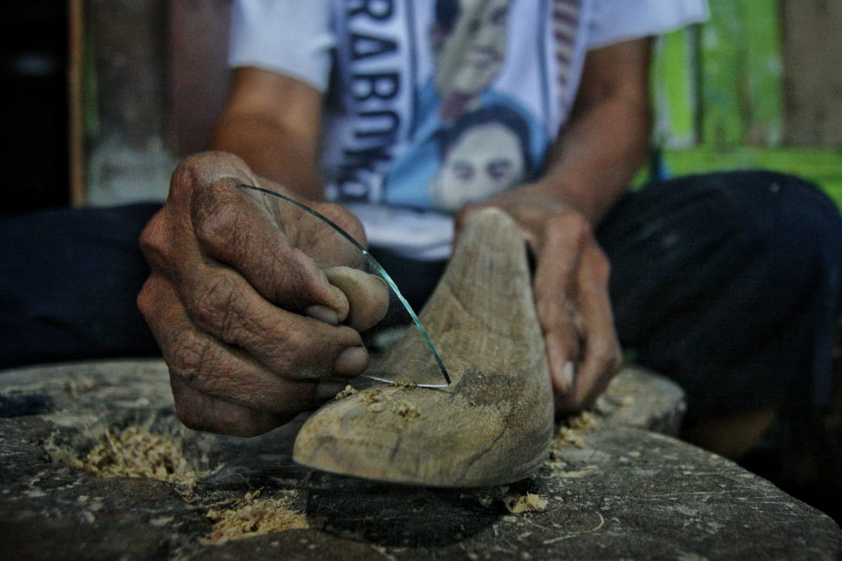 Proses menghaluskan cetakan sepatu berbahan kayu menggunakan kaca di Medan Denai, Medan, Sumatera Utara